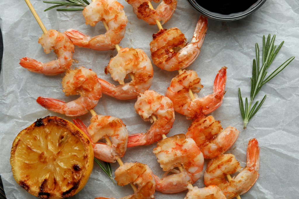 Tasty grilled shrimps on rustic wooden background