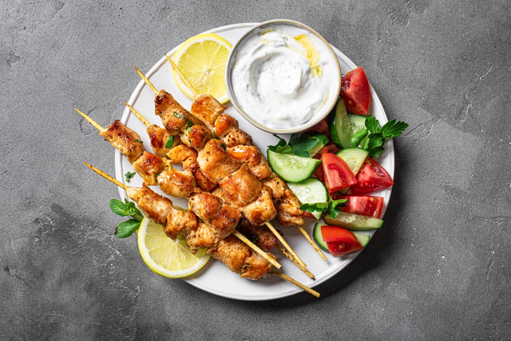 Mediterranean lunch with souvlaki skewers, yogurt sauce and vegetables