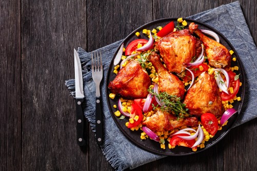 roast chicken with corn and tomatoes on plate