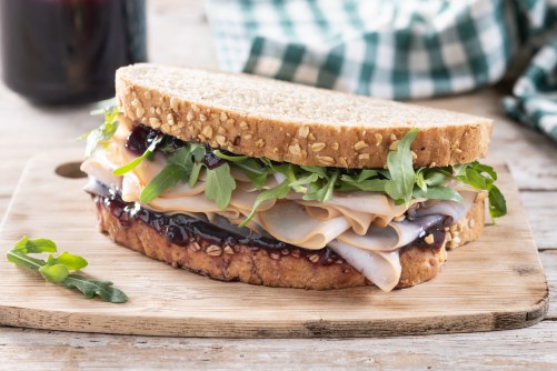 Turkey sandwich with cranberry sauce for Thanksgiving on wooden